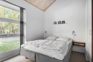 a bed in a room with a large window at 6715-Hasle-Skovkanten-12 in Hasle