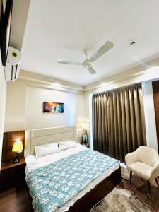 a bedroom with a bed and a chair and a window at D Haven Stays in Greater Noida +10 photos