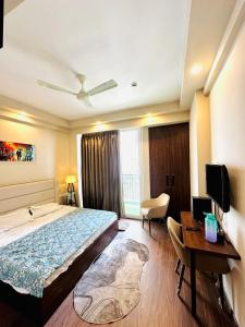 a hotel room with a bed and a desk and a television at D Haven Stays in Greater Noida
