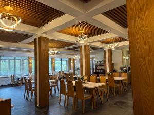 a restaurant with tables and chairs in a room at Hotel Beskidian in Węgierska Górka