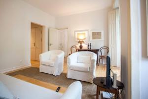a living room with two white chairs and a table at LovelyStay - Elegance and Charm! in Lisbon