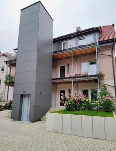 a tall building with flowers in front of it at Ferienwohnungen am Wasserfall in Bad Urach