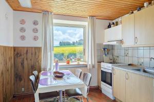 a kitchen with a table with chairs and a window at 9116-Gudhjem-Rovej-22 in Gudhjem