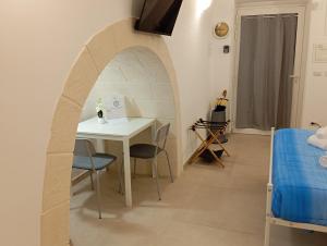 a room with a table and chairs and a bed at Ranieri rooms & relax Mare in Mola di Bari +7 photos