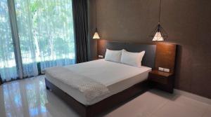 a bedroom with a bed and a large window at Ivory Villas & Resort - Villa view hồ Lake View in Rống Vong +9 photos