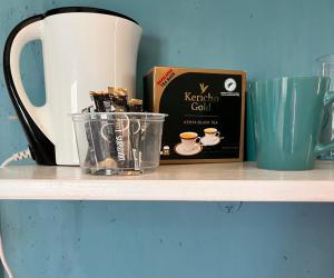 a shelf with a coffee pot and a box on it at Khangadelic Kilifi in Kilifi +37 photos