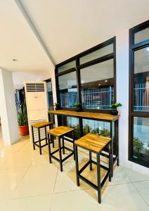two tables and two stools in a room with windows at Nambis Inn in Madang