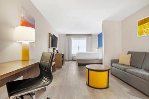 a hotel room with a couch and a bed at Comfort Inn & Suites Dothan Northside Plaza in Dothan