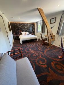 a living room with a bed and a carpet at Hôtel Roc Land in Val Couesnon