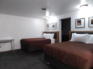 a hotel room with two beds and a table at Neva Jean Motel in Marshfield