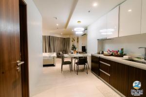a kitchen and living room with a table and a bed at Tambuli Seaside Living Pad seaview in Maribago