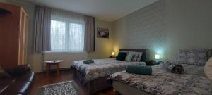 a hotel room with two beds and a couch at Villa VértesKacsa in Vértesacsa