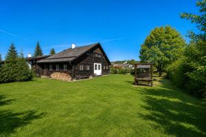 a large yard with a barn and a grass field at Penzion Sněžná Volary in Volary