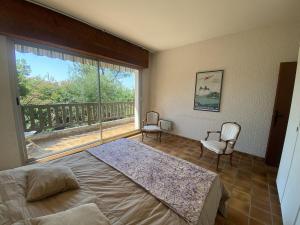 a bedroom with a bed and a large window at Beach house within walking distance in La Teste-de-Buch
