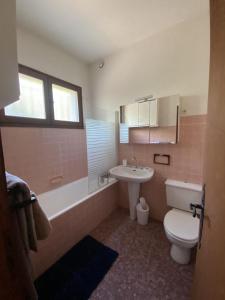 a bathroom with a toilet and a sink and a tub at Beach house within walking distance in La Teste-de-Buch