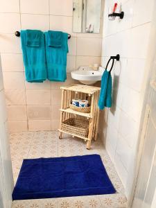 a bathroom with a sink and a blue rug at Khangadelic Kilifi in Kilifi