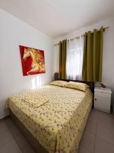 a bedroom with a bed with a horse painting on the wall at Willy Apartments in Velipojë