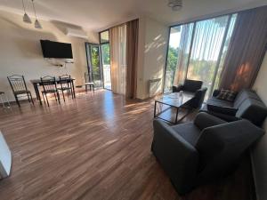 a living room with a couch and chairs and a table at Park & Sea Townhouse in Makhinjauri