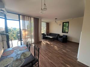 a living room with a table and chairs and a couch at Park & Sea Townhouse in Makhinjauri