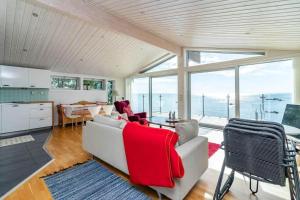 a living room with a couch and a kitchen with windows at VGO1064-Karlsborg-Silverdalen-1 in Karlsborg