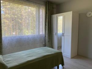 a bedroom with a bed and a large window at Just home in Hamina