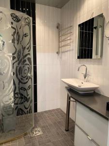 a white bathroom with a sink and a shower at Just home in Hamina