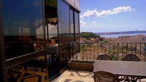 a balcony with a table and chairs and a view at Albergaria Senhora do Monte in Lisbon