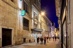 a group of people walking down a street at night at Quality Hotel Bordeaux Centre in Bordeaux