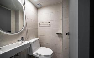 a bathroom with a toilet and a sink and a mirror at Lime Hotel in Busan +15 photos