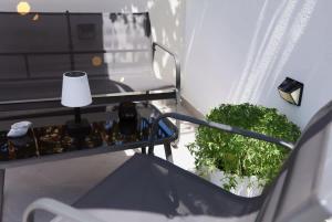 a balcony with a table and a chair and a lamp at Apartment Simply 101 in Gázion