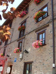 un edificio de piedra con flores en vidrieras en La Cuculla, en Ezcaray