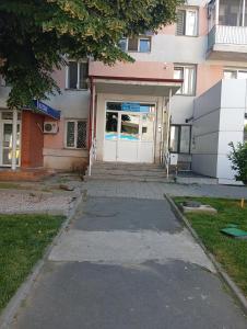 a building with a white door and a sidewalk at Apartament Pro Confort in Tulcea