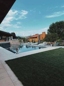 a swimming pool in a yard with a lawn at Residenza Monticelli in Lavagno