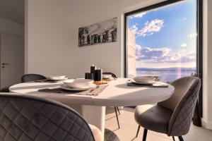 a dining room with a table and chairs and a large window at Luxurious Sea-view 3BR Apartment with Private Pool-Villa Quadris-Crikvenica in Crikvenica