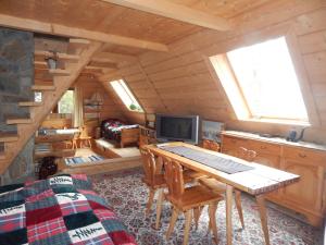 a living room with a table and a television in a cabin at Chata Stacha in Zakopane
