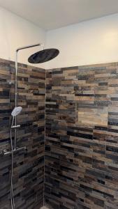 a bathroom with a wall made out of wood at Bungalow Omati in Tahateao