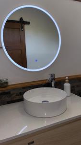 a bathroom sink with a large mirror above it at Bungalow Omati in Tahateao