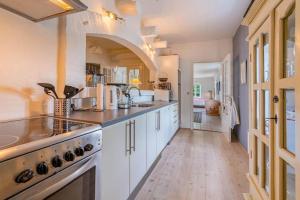 a large kitchen with white cabinets and a wooden floor at HS025-Outrup-Strandvejen-31-B in Henne