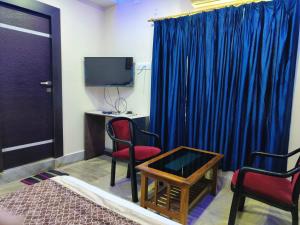 a room with a tv and two chairs and a table at Hotel #Blue Moon# Front Of Bhubaneswar Railway Station in Bhubaneshwar