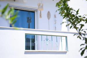 a window of a white house with some decorations at Apartment Simply 203 in Gázion