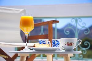 a glass of orange juice sitting on a table with coffee cups at Apartment Simply 203 in Gázion