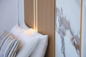 a bed with white pillows next to a mirror at Apartment Simply 203 in Gázion