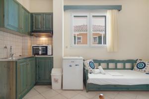 a kitchen with a bed and a window and a refrigerator at Odysseia Beachside Apartments in Nikiana