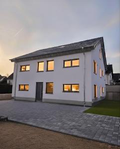 a white house with its lights on at Ferienwohnungen im Neubau in Ringen