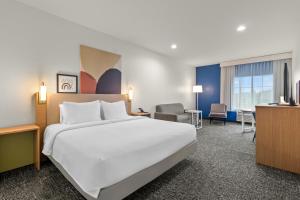 a hotel room with a large bed and a desk at Spark By Hilton Missouri City in Missouri City +59 photos