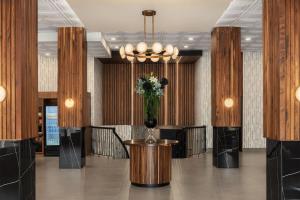 a lobby with a table with a vase of flowers at Le Parc Gatineau, Tapestry Collection by Hilton in Gatineau +72 photos