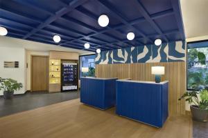 a lobby with blue walls and potted plants at Spark By Hilton Goa Calangute in Goa