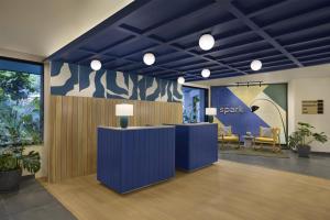 an office lobby with blue walls and potted plants at Spark By Hilton Goa Calangute in Goa