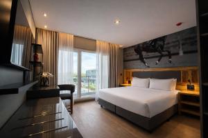 a hotel room with a bed and a picture of a person jumping at Radisson Red Funes in Rosario +41 photos