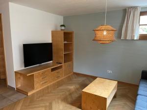 a living room with a flat screen tv and a table at Familie Jäger in Innerbraz